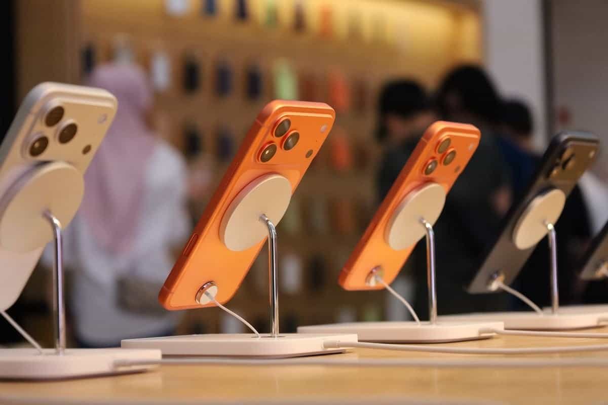Rows of iPhones on display stands inside an Apple Store during a launch day