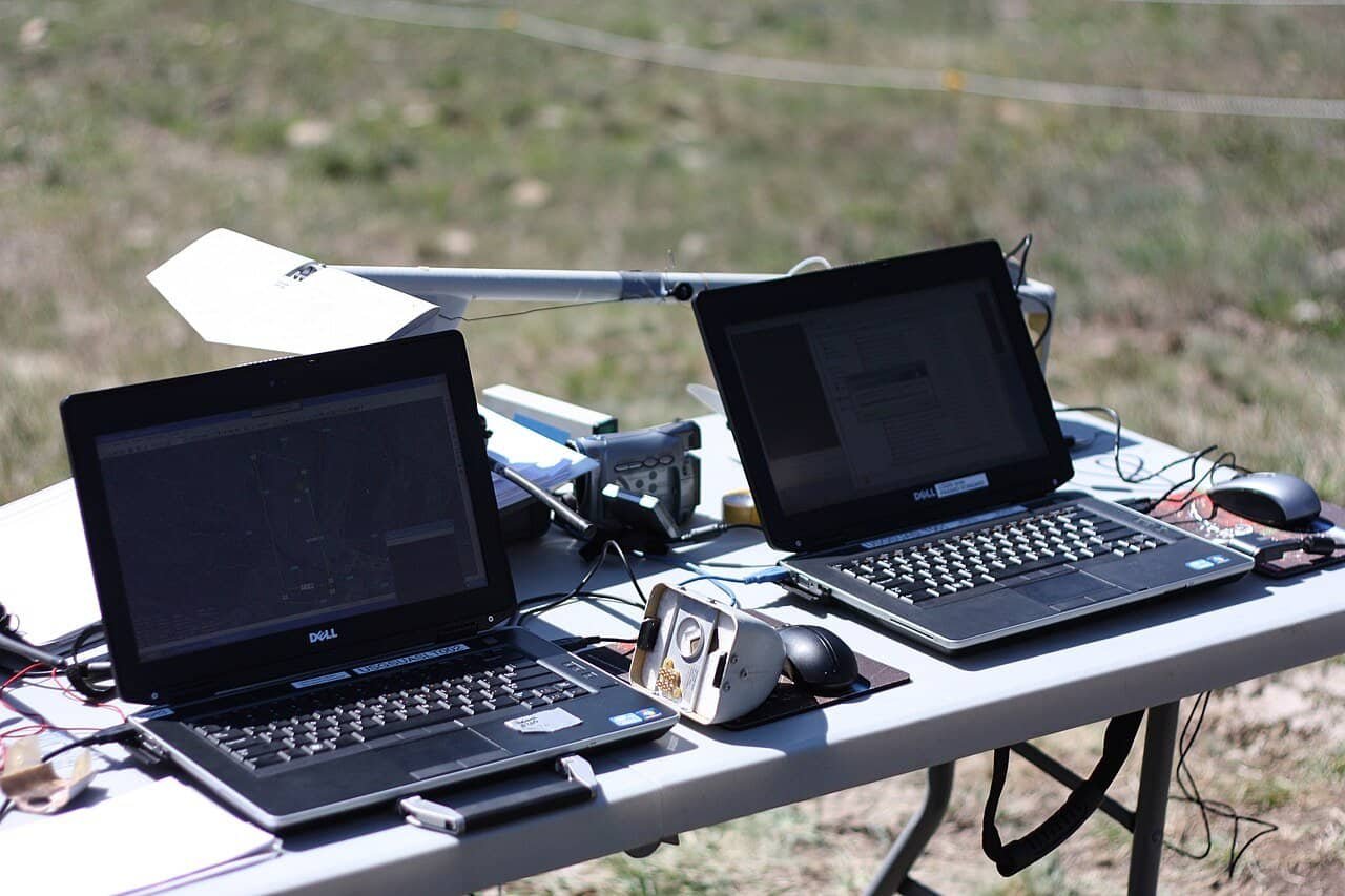 Two open laptops side by side on a wooden table