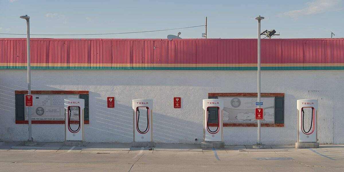 Four Tesla Supercharger stalls in front of a roadside restaurant in Inyokern, California