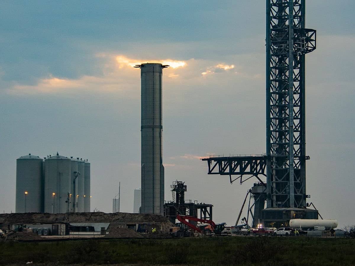 SpaceX Super Heavy booster, propellant tank farm and launch tower at Starbase, Texas, at dusk