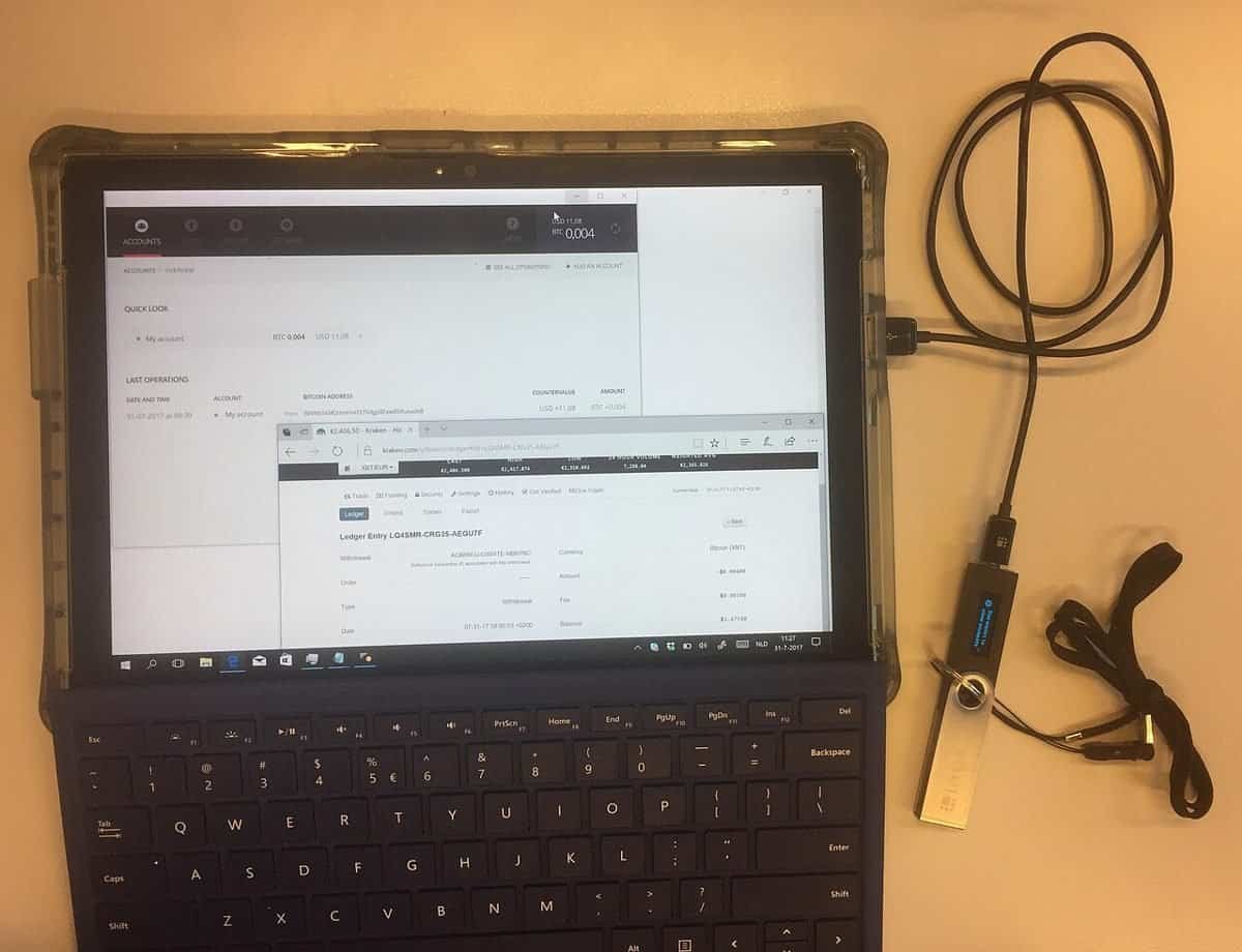 Ledger hardware wallet connected to a laptop showing a bitcoin transaction