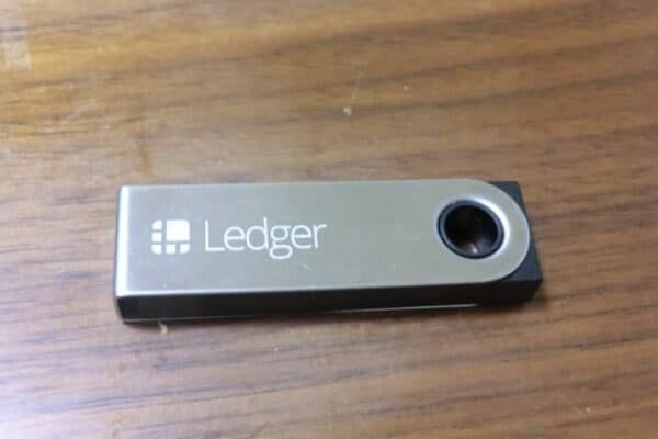 Ledger hardware wallet lying on a wooden table