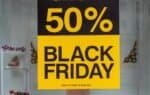 Yellow and black "50% Black Friday" sale sign in a shop window