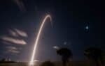 SpaceX Falcon 9 rocket launch arcing into the night sky over Cape Canaveral